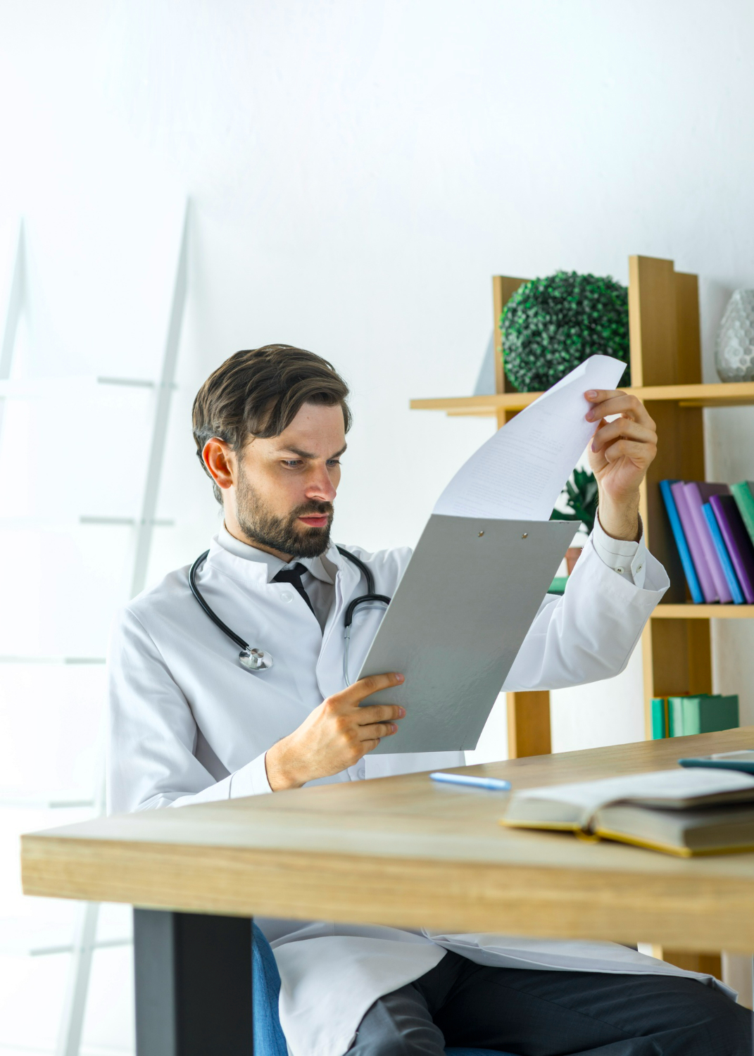 Success Mindset Resources for Surgeons Featured Image - Young Doctor Reading Notes on Clipboard